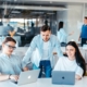 IT-Team bespricht gemeinsam Aufgaben am Laptop