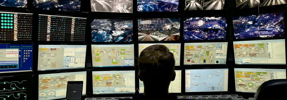 Person vor einer Monitorwand in einer Sicherheits-Leitstelle