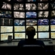 Person vor einer Monitorwand in einer Sicherheits-Leitstelle